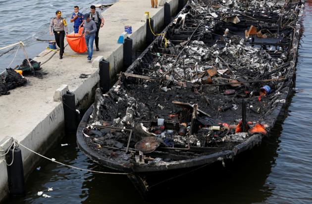 The remains of a victim is carried away after a fire ripped through a boat carrying tourists to islands north of the capital at Muara Angke port in Jakarta on January 1. (REUTERS)