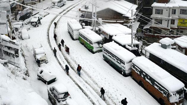 People walk on the snow-covered road at Sanjauli, Shimla on January 7. (Deepak Sansta / Ht photo)