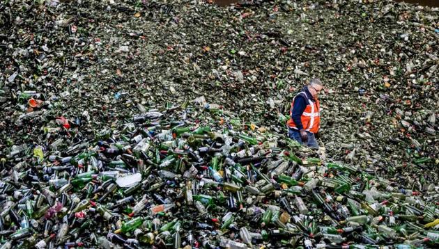 A man stands among bottles at the Van Tuijl glass recycling plant following Christmas and New Year celebrations in Gameren, the Netherlands, on January 3. (AFP)