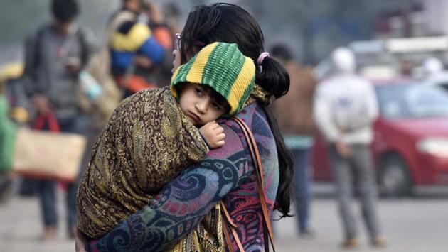 Passengers at Nizamuudin Railway Station protect themselves from the cold on a winter morning  in New Delhi.  (Saumya Khandelwal/HT PHOTO) 
