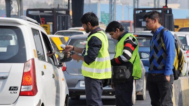 A toll attendant gives a payment slip from a hand held swipe machine to car drivers at the Kherki Daula toll plaza. (HT File) A toll attendant gives a payment slip from a hand held swipe machine to car drivers at the Kherki Daula toll plaza. (HT File)