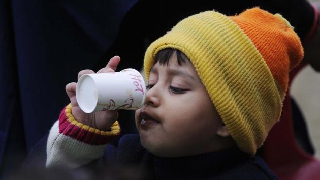 A child enjoys tea on a foggy morning  in Lucknow. (Deepak Gupta / Ht photo) 