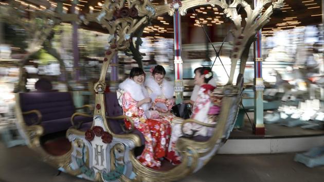A group of women gets on a merry-go-round. (AP)