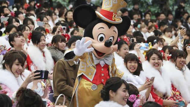 Mickey Mouse waves at the young Japanese who celebrate becoming 20 years old during the coming of age ceremony. (Koji Sasahara / AP)
