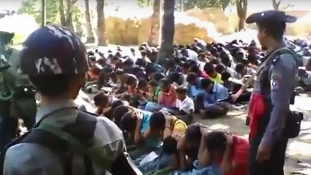 Screengrab from a video, originally taken by a Myanmar constable, shows policemen standing guard around Rohingya minority villagers in Kotankauk village during a police area clearance operation on November 5, 2016.(AFP file photo)