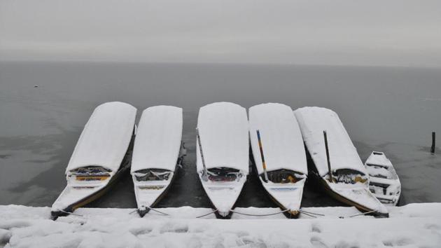 Snow-covered Shikara boats are moored to the bank of the semi-frozen Dal lake in Srinagar. (Waseem Andrabi / HT Photo) 