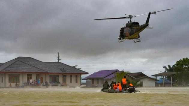 This January 7, 2017, photo shows a rescue boat and a helicopter moving towards a group of stranded people in the Srinakarin district of the southern Thai province of Phattalung. (AFP) This January 7, 2017, photo shows a rescue boat and a helicopter moving towards a group of stranded people in the Srinakarin district of the southern Thai province of Phattalung. (AFP)