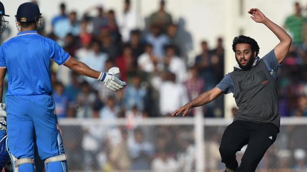 A fan evaded security and ran on to the ground to greet Mahendra Singh Dhoni during the first warm-up one day cricket match between India A and England XI at the Brabourne Stadium in Mumbai on Tuesday.(AFP)