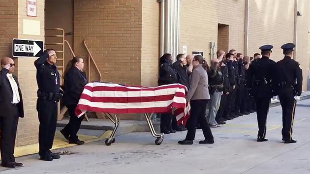 Officers salute as Sgt. Debra Clayton’s body is transported, in Orlando. (AP Photo)