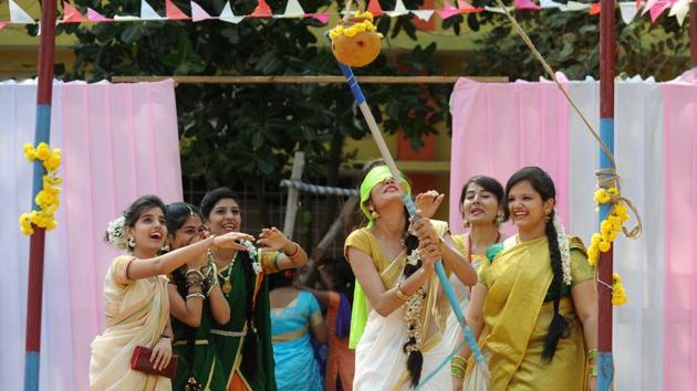 A student, with a blindfold on, tries to break a mud pot at a college in Chennai on Wednesday. (AFP)