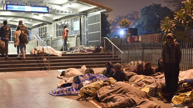 Patients at AIIMS and their families sleep outside the Metro Station in the open during extreme cold. (Saumya Khandelwal/HT PHOTO)