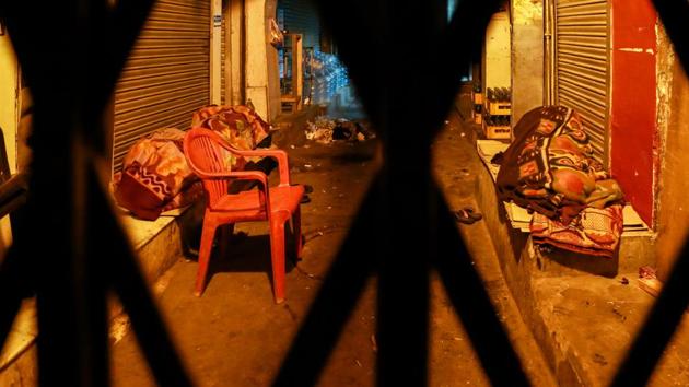 BEHIND BARS: Two daily wage workers sleep in front of shops in a lane at Chandni Chowk. (AMAL KS/HT PHOTO) 