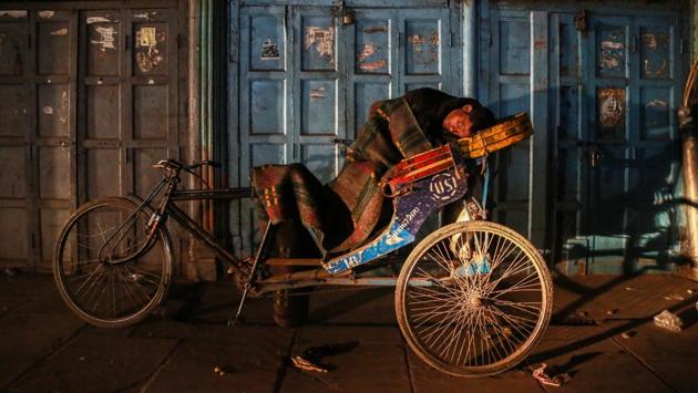 DISCOMFORT ZONE: A man turns his rickshaw into a bed for the night because the floor is too cold to sleep on.   (AMAL KS/HT PHOTO) 