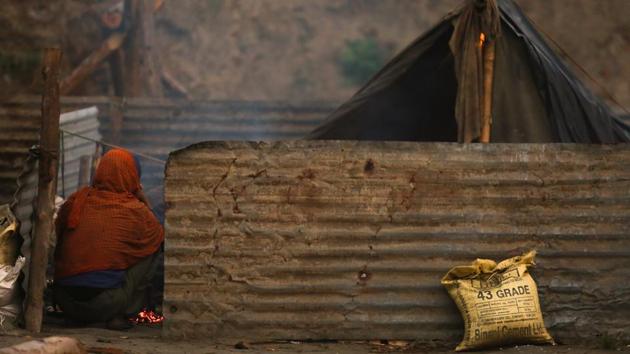 FIGHTING THE ODDS: A man sitting in his makeshift tin home near Yamuna bank. (AMAL KS/HT PHOTO) 