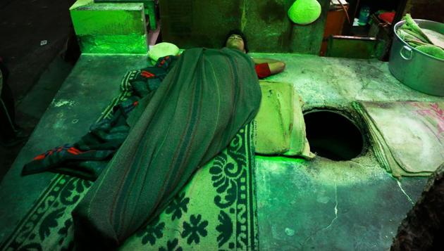 AT PEACE: A young worker sleeps next to a tandoor outside a shop near Jama Masjid. (AMAL KS/HT PHOTO) 