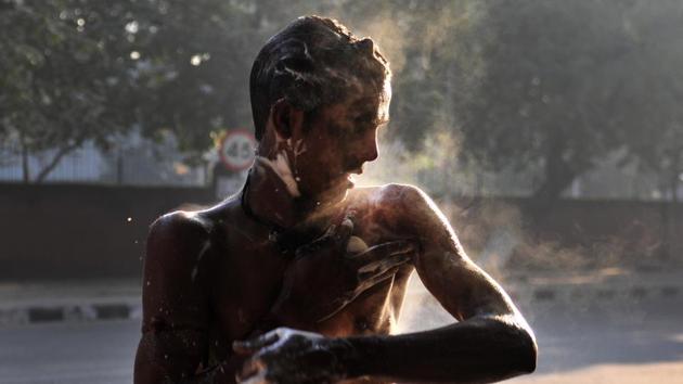 An auto rickshaw driver taking bath on a cold winter morning at Chandigarh. (karun sharma/ht photo)