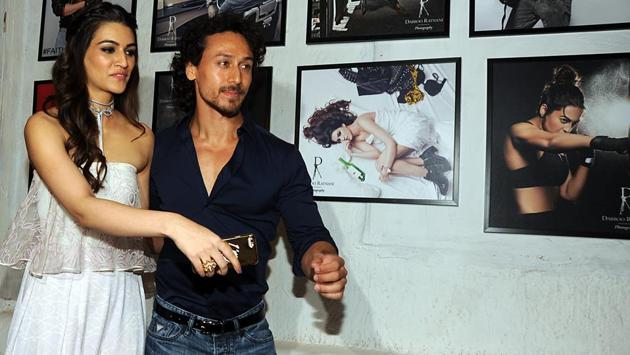 Kriti Sanon (L) and actor Tiger Shroff pose in front of the photographs. (AFP) Kriti Sanon (L) and actor Tiger Shroff pose in front of the photographs. (AFP)