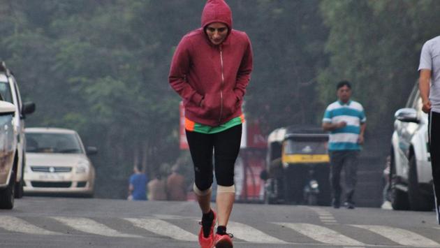 With the temperatures falling drastically, it seems to be a hard task for this lady to jog in Thane City. (Praful Gangurde/ht photo)