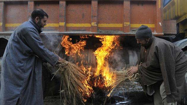 Drivers heating frozen truck fuel tank by burning fire below it on a cold winter morning in Srinagar. (waseem andrabi/ht photo)