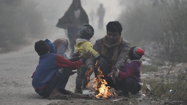 Homeless people warm themselves around a bonfire on a cold winter morning. Delhi today witnessed the coldest day of the season with temperature falling to 2.3 degrees Celsius at some parts of the national capital region in New Delhi. (Raj K Raj/HT PHOTO)