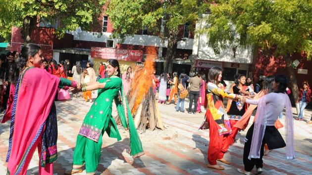 Girls dancing around a bonfire during Lohri celebration at MCM College, Sector 36 in Chandigarh on Friday. (Anil Dayal/HT Photo)