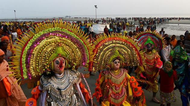 Folk dancers perform the ‘Chhou’ dance for Hindu devotees taking a holy bath and performing rituals at the Gangasagar Island. (Dibyangshu SARKAR / AFP Photo) 
