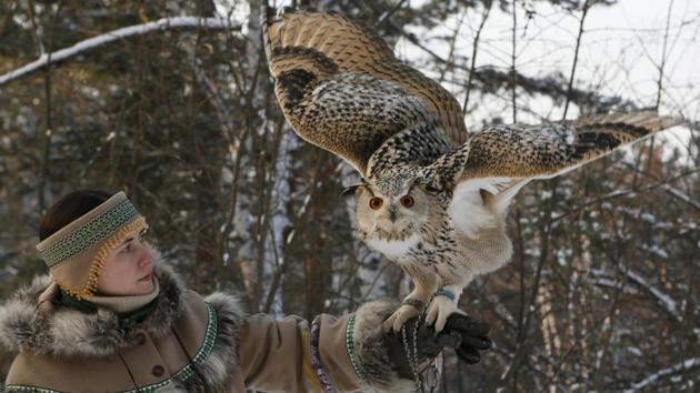 Zoo employee Daria Zhirnova dressed in an Evenki traditional costume, holds Pykh, an 8-month-old eagle owl, during a training session which is a part of Royev Ruchey zoo's programme of taming wild animals for research, and for enlightenment and interaction with visitors, in the Siberian taiga forest in the suburb of Krasnoyarsk. (Ilya Naymushin / REUTERS) Zoo employee Daria Zhirnova dressed in an Evenki traditional costume, holds Pykh, an 8-month-old eagle owl, during a training session which is a part of Royev Ruchey zoo's programme of taming wild animals for research, and for enlightenment and interaction with visitors, in the Siberian taiga forest in the suburb of Krasnoyarsk. (Ilya Naymushin / REUTERS)