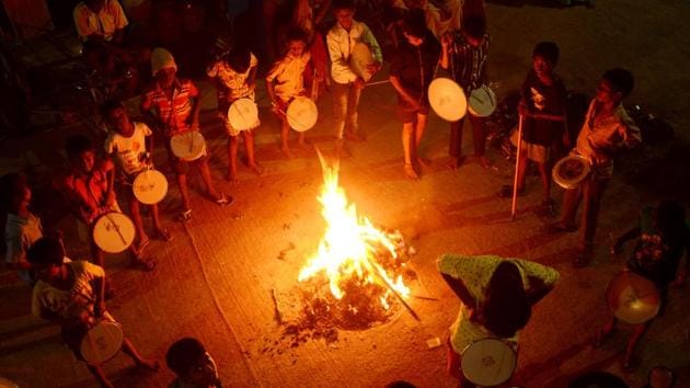 People gather around the bonfire on Friday to celebrate Bogie Pongal. On this day people discard old things and focus on new belongings. House are cleaned painted and decorated for a festive look. (V Srinivasulu / HT Photo)