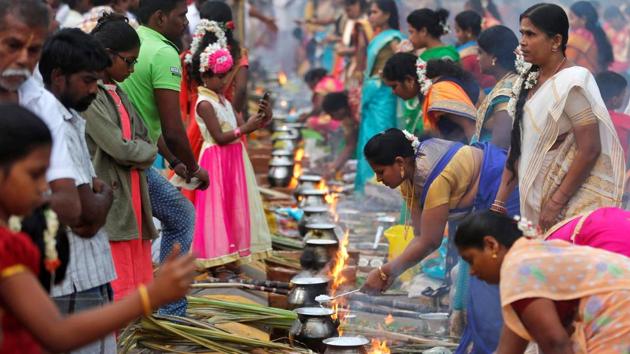 Devotees prepare rice dishes to offer to the Hindu Sun God as they attend Pongal celebrations early morning in Mumbai on Saturday. (REUTERS)