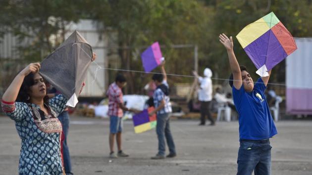 Children and adults fly their kites during Makar Sankranti near Bhakti Park. (Arijit Sen/HT PHOTO)