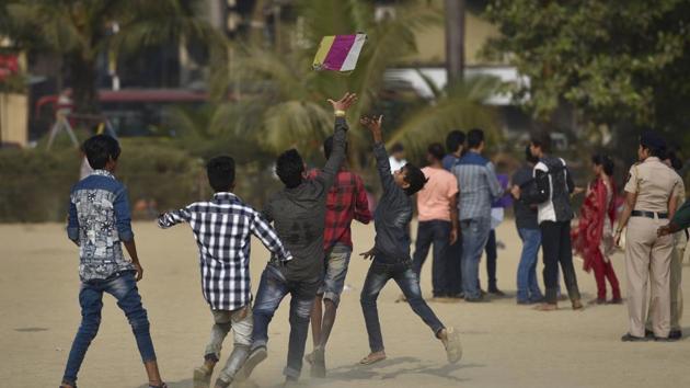 Youngsters run after kites at Girgaum beach. (Arijit Sen/HT PHOTO)