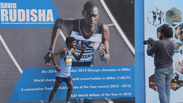 An athlete pose against the poster of David Rudisha (800m olympic champion) during the Mumbai Marathon 2017 (Pramod Thakur/HT PHOTO) 