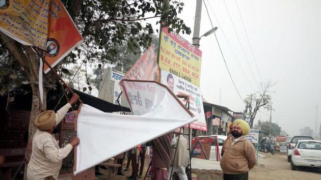 Officials removing hoardings by political parties in Ludhiana on Saturday. (HT Photo) Officials removing hoardings by political parties in Ludhiana on Saturday. (HT Photo)