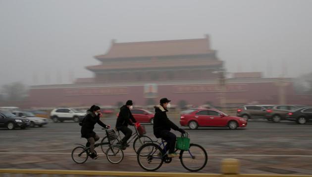 People wearing masks cycle past Tiananmen Gate during the smog after a red alert was issued for heavy air pollution in Beijing, China on December 20, 2016. (REUTERS FILE) People wearing masks cycle past Tiananmen Gate during the smog after a red alert was issued for heavy air pollution in Beijing, China on December 20, 2016. (REUTERS FILE)