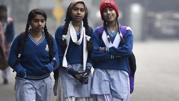 Girls walk to school on a cold winter morning with overcast skies. (Raj K Raj/HT PHOTO)