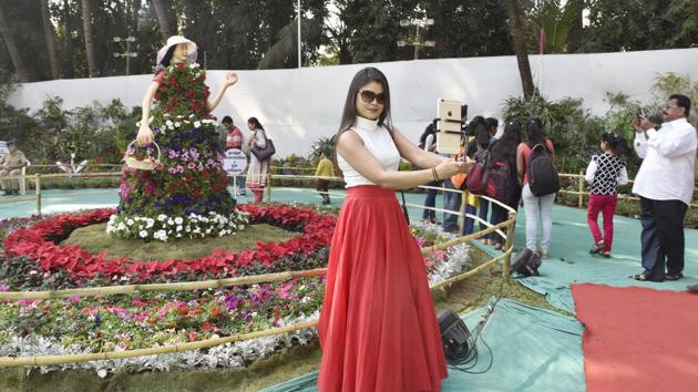 A woman mimics the pose of the Barbie exhibit behind her and takes a selfie.  (Anshuman Poyrekar/HT ) 