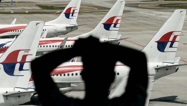 This file picture taken on February 25, 2016 shows a man looking at Malaysia Airlines' aircraft parked on the tarmac at Kuala Lumpur International Airport in Sepang. (AFP)