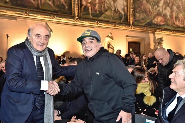 Maradona (right) shakes hands with former Napoli president Corrado Ferlaino during the ceremony. (AP)