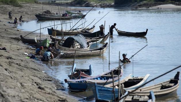 This photo taken on November 23, 2016 shows people going about their activities along the Irrawaddy river near Mandalay. On this stretch of river in Myanmar the animals have developed a deep bond with local fishermen, who they work with in a generations-old partnership that has become the stuff of local folklore. (Ye Aung Thu/AFP)