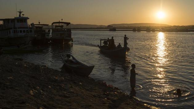 This photo taken on November 23, 2016 shows people using boats to travel over the Irrawaddy river near Mandalay. For Irrawaddy locals, losing the dolphins is not just about destroying traditions from their past -- it threatens their future. With fish stocks plummeting there are hopes ecotourism will prove a lifeline to bolster meagre incomes. (Ye Aung Thu/AFP)