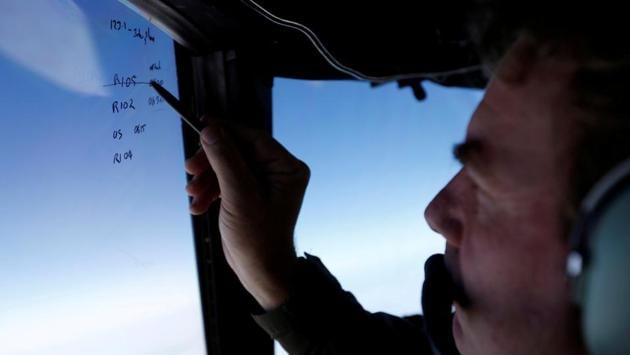 Squadron leader Brett McKenzie marks the name of another search aircraft on the windshield of a Royal New Zealand Air Force P-3K2 Orion aircraft searching for missing MH370 over the southern Indian Ocean on March 22, 2014. (REUTERS)