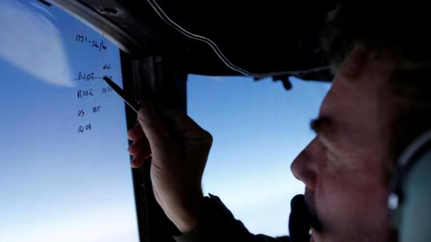 Squadron leader Brett McKenzie marks the name of another search aircraft on the windshield of a Royal New Zealand Air Force P-3K2 Orion aircraft searching for missing Malaysian Airlines flight MH370 over the southern Indian Ocean March 22, 2014.(Reuters)