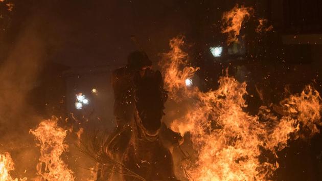A horseman jumps over a bonfire... (AFP) A horseman jumps over a bonfire... (AFP)