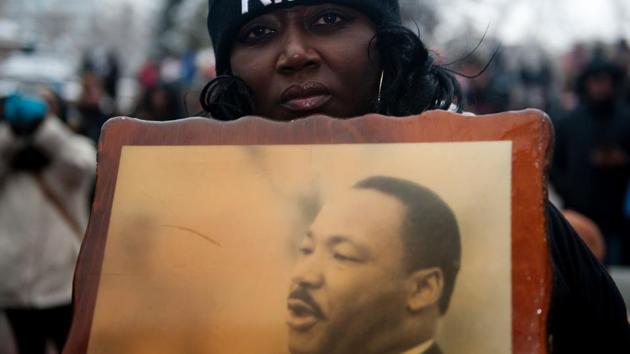 Bridget Johnson holds a picture of the late Dr. Martin Luther King Jr. while marching in Denver, Colorado during Denver's Martin Luther King Jr. parade. (Jason Connolly/AFP) Bridget Johnson holds a picture of the late Dr. Martin Luther King Jr. while marching in Denver, Colorado during Denver's Martin Luther King Jr. parade. (Jason Connolly/AFP)