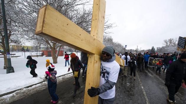Minister Walle Williams, of Street Ministries, carries a large cross during Denver's Martin Luther King Jr. parade. (Jason Connolly/AFP) Minister Walle Williams, of Street Ministries, carries a large cross during Denver's Martin Luther King Jr. parade. (Jason Connolly/AFP)