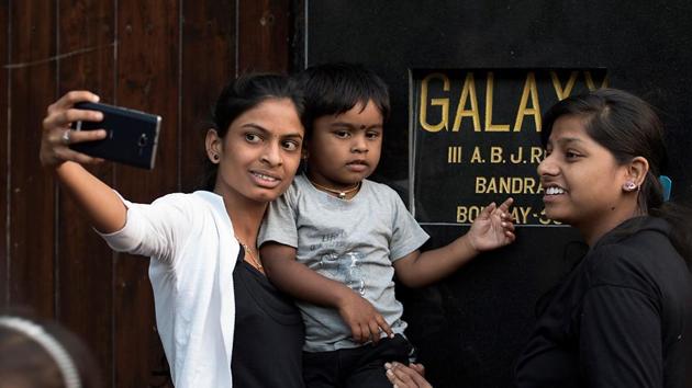 A woman takes a photo outside his residence  in Mumbai. (Satish Bate/HT PHOTO) 