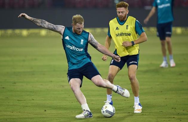 England's Jonny Bairstow (R) and Ben Stokes kick a ball during a training session at the Barabati stadium. (AFP)