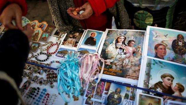 A woman buys souvenirs after a holy mass outside San Anton Church in Madrid, Spain. (Juan Medina/REUTERS) A woman buys souvenirs after a holy mass outside San Anton Church in Madrid, Spain. (Juan Medina/REUTERS)