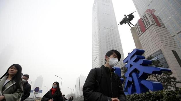 People wearing masks walk past Yintai Centre during the smog after a red alert was issued for heavy air pollution in Beijing's central business district, China. (Reuters Photo) People wearing masks walk past Yintai Centre during the smog after a red alert was issued for heavy air pollution in Beijing's central business district, China. (Reuters Photo)