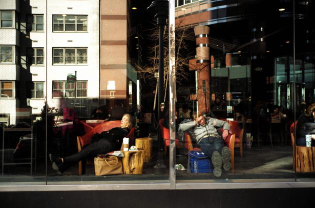 A woman and a man take nap sitting on armchairs at a Starbucks cafe in New York(AFP)